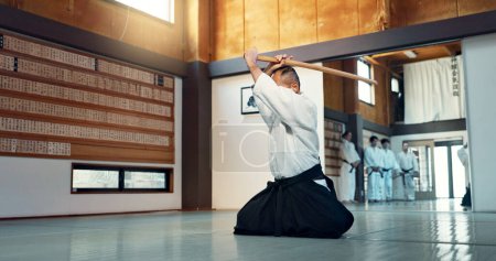 Photo for Aikido sword, mature sensei and man teaching class, self defense or combat technique. Martial arts, Japanese person and wooden weapon for skills development, attack demonstration or bokken strike. - Royalty Free Image