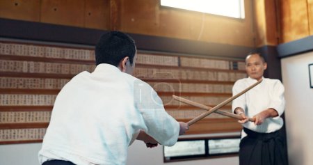 Photo for Asian man, taekwondo and training with wooden sticks for martial arts, fighting or sparring partner in dojo. People in fight practice with dummy weapon to opponent in karate for self defense at gym. - Royalty Free Image
