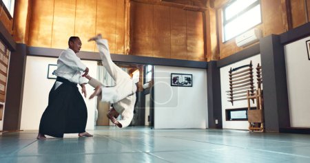 Foto de Aikido, lucha y sensei maestro en artes marciales con formación de estudiante en defensa propia o disciplina. Clase, demostración y hombre japonés con cinturón negro en la lucha por la educación de la habilidad. - Imagen libre de derechos