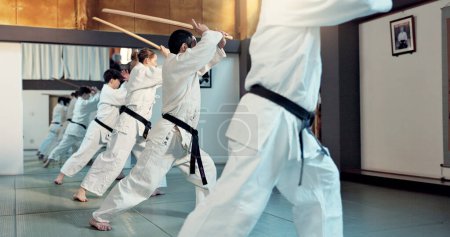 Téléchargez les photos : Arts martiaux, cours d'aikido et les gens avec la discipline d'entraînement, l'autodéfense et la technique de l'épée de pratique. Étudiants ceinture noire, groupe japonais et développement des compétences d'apprentissage pour la protection dans le dojo. - en image libre de droit