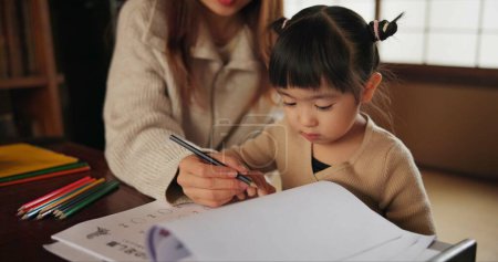 Photo for Mother, child and drawing learning or pencil for home schooling lesson, Japanese or tutor. Female person, girl daughter and book paper in Tokyo or writing help for art studying, creative or project. - Royalty Free Image