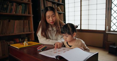 Photo for Child, mother and teaching education in home for drawing in Japanese or tutor schooling, development or book. Female person, girl daughter and pencils in Tokyo or writing lesson, studying or creative. - Royalty Free Image
