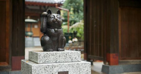 Photo for Maneki neko, statue and Japanese or traditional temple at woods garden for respect, worship or spirituality. Sculpture, lucky cat and outdoor or traveling adventure in Tokyo, Gotokuji and fortune. - Royalty Free Image