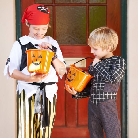 Photo for Halloween, candy and door with children in costume on porch for trick or treat celebration together. Friends, food and sweets with young boy kids in fancy dress for spooky holiday or vacation. - Royalty Free Image