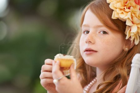 Photo for Child, girl and eating cupcake or sweets outdoor for birthday food or celebration, dessert or candy. Female person, happy kid and sweet snack at garden event for hungry for treat meal, party or fun. - Royalty Free Image
