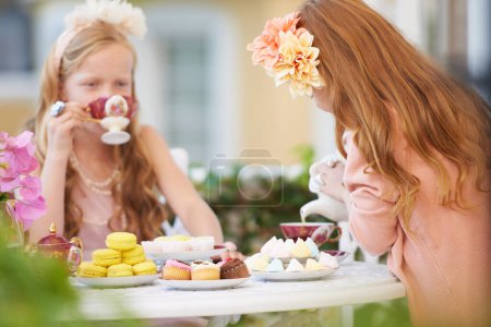 Photo for Girls, children and friends at tea party in nature for fantasy play for cake, birthday or game. Kids, food and fancy dress up or flower crown or outdoor for summer bonding, backyard or macarons. - Royalty Free Image