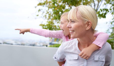 Téléchargez les photos : Happy, piggyback et mère avec un enfant pointant pour visiter la nature, le parc ou le jardin. Sourire, amusant et jeune maman portant fille enfant pour coller et jouer ensemble sur une aventure dans un champ - en image libre de droit