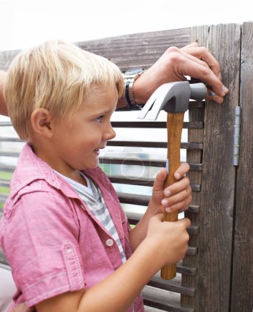 Photo for Happy, hammer and boy kid doing maintenance on wood gate for fun or learning. Smile, equipment and young child looking and working on repairs with tool for home improvement outdoor at modern house - Royalty Free Image