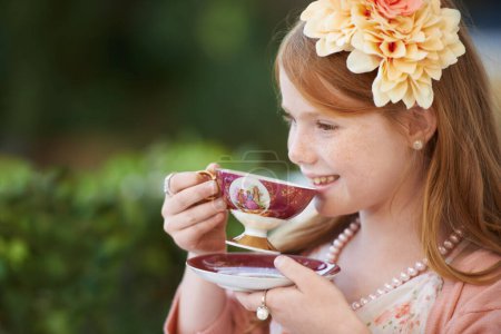 Photo for Girl, child and smile with tea in garden with party for birthday, celebration and playing outdoor in home. Person, kid and porcelain cup in backyard of house with dress up, beverage and role play fun. - Royalty Free Image