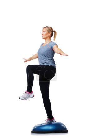 Foto de Mujer, bola de bosu y ejercicio de equilibrio para entrenamiento o entrenamiento corporal en un fondo de estudio blanco. Persona femenina activa en medio objeto redondo para pilates, práctica o salud y fitness en espacio de maqueta. - Imagen libre de derechos
