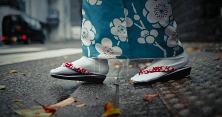 Téléchargez les photos : Pieds, chaussures japonaises et traditionnelles avec promenade en ville pour voyager et voyager en plein air. Mode, aventure et rue urbaine à Kyoto, kimono pour la culture et le style avec une personne en voyage local pour le tourisme. - en image libre de droit