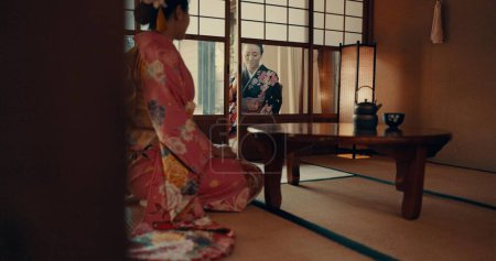 Téléchargez les photos : Japonais, femmes et kimono dans le couloir pour la cérémonie dans la salle de chashitsu avec la mode ou les vêtements indigènes. Personnes, rituels et culture pour temae, bien-être et zen dans un bâtiment d'architecture à Tokyo. - en image libre de droit