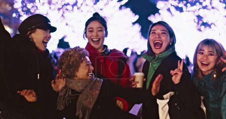 Photo for Women, city or happy people in festival, party or night event on holiday vacation on New Years. Japanese, dancing or group of friends laughing together with energy, freedom or lights with peace sign. - Royalty Free Image