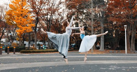 Foto de Ballet, baile y mujeres en otoño en la calle en Japón parque con zapatos puntiagudos y pose creativa. Al aire libre, bailarina y personas con rendimiento de talento, arte y piernas estiradas en Kyoto. - Imagen libre de derechos