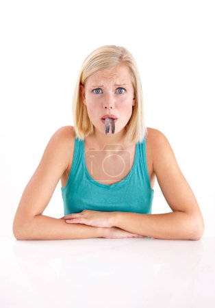 Photo for Confused, woman and portrait of eating fish, tail or strange food in mouth on white background of studio. Crazy, diet and person with weird seafood, cuisine or disgust for taste of tuna or salmon. - Royalty Free Image