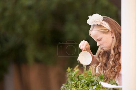 Photo for Child, tea and pouring or disgust in garden for gross taste at party event or unhappy, drink or disappointed. Female person, girl and cup or warm beverage fail for strong flavour, outdoor or backyard. - Royalty Free Image