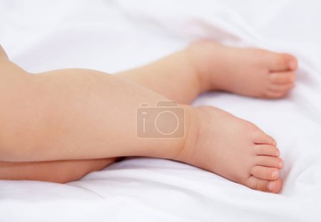 Photo for Feet, baby and legs of kid on bed for sleep, calm break and relax in nursery room at home. Closeup, foot and toes of tired young child asleep for newborn development, healthy childhood growth or rest. - Royalty Free Image