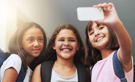 Foto de Amigos, niños y sonreír para selfie en la escuela primaria, la memoria educativa y el aprendizaje juntos. Diversidad, jóvenes estudiantes y grupo de chicas tomando fotos para las redes sociales, fotografía o diversión. - Imagen libre de derechos