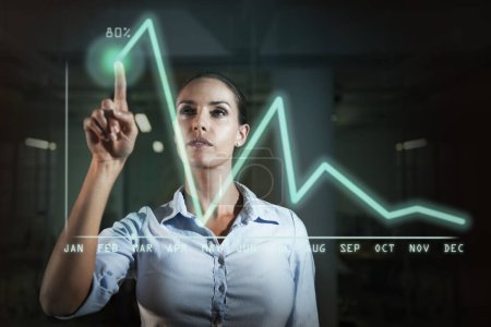 Photo for Business woman, graph and finance with overlay, calendar and thinking with investment, growth or revenue. Person, stock market or economy with point at holographic chart for data analysis in night. - Royalty Free Image