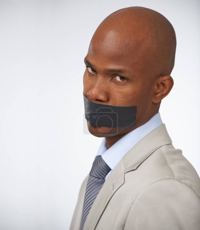 Photo for Businessman, portrait and tape on mouth silence or corporate censored for secret, blackmail or quiet. Black person, face and journalist in company career trouble or white background, studio or mockup. - Royalty Free Image