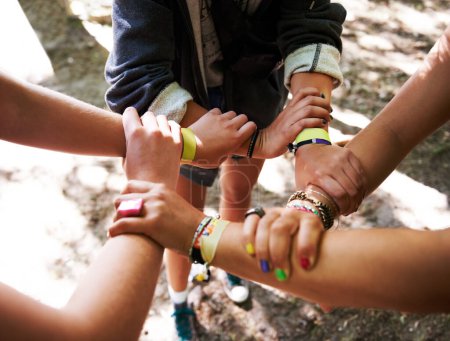 Photo for People, hands together and outdoor festival with arm bands for community, teamwork or unity at event. Group of friends piling or circle for synergy, motivation or party at music carnival outside. - Royalty Free Image