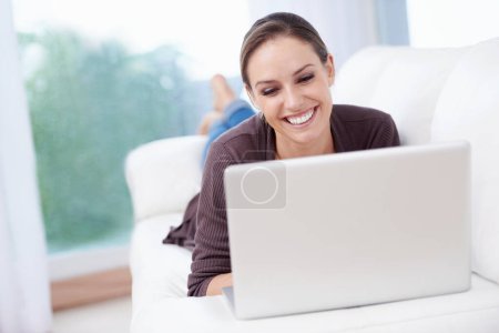 Photo for Happy woman, laptop and relax on couch for remote work, streaming movies and update blog post at home. Freelancer, computer and download subscription, online shopping and search news on social media. - Royalty Free Image