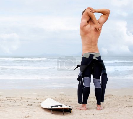 Foto de Detrás del surfista, el hombre se está estirando y la playa, tabla de surf para las olas del océano y empezar a fitness, aventura y viajes. Naturaleza, vacaciones y surf en Hawaii, vacaciones de verano en una isla y deportes extremos. - Imagen libre de derechos