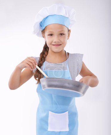 Photo for Child, chef and portrait with apron, confident and development on white background. Culinary skills, happy and learning to cook, food and childhood growth with confidence in hospitality industry. - Royalty Free Image