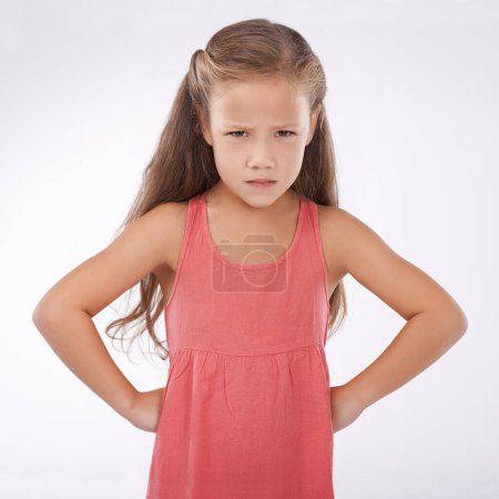 Photo for Child, portrait and unhappy grumpy in studio or bad mood discipline or development, trouble or angry. Female person, hands and hips in frustration for girl kid as white background, attitude or mockup. - Royalty Free Image