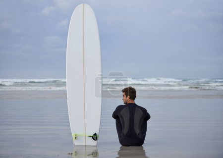 Téléchargez les photos : Plage, fitness et pensée d'homme avec une planche de surf pour le bien-être, le sport et l'entraînement tout en étant assis dans la nature. Eau, exercice et dos de surfeur masculin à l'océan avec la paix, le calme et le passe-temps de la mer à Bali. - en image libre de droit