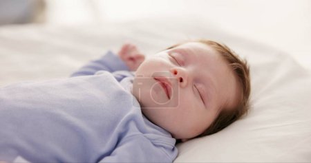 Téléchargez les photos : Détendez-vous, grandissez et dormez avec un bébé dans une chambre à coucher en gros plan dans une maison, rêvant pendant une sieste pour le développement de l'enfant. Enfants, calme et repos avec un adorable nouveau-né endormi sur un lit pour plus de confort. - en image libre de droit