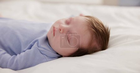 Téléchargez les photos : Détendez-vous, grandissez et dormez avec un bébé sur un gros plan de lit dans une maison, rêvant pendant une sieste pour le développement de l'enfant. Enfants, calme et repos avec un adorable nouveau-né endormi dans une chambre pour plus de confort. - en image libre de droit