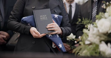 Photo for Hands, american flag and bible with a person at a funeral, grieving a loss at a graveyard. War, cemetery and death with an army wife at a memorial service to say goodbye to a fallen soldier closeup. - Royalty Free Image