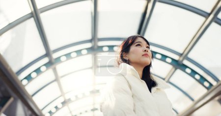 Photo for Thinking, city and Japanese woman on bridge on commute, travel and journey in metro. Student, fashion and person with trendy clothes, backpack or bag for university, college and adventure in town. - Royalty Free Image