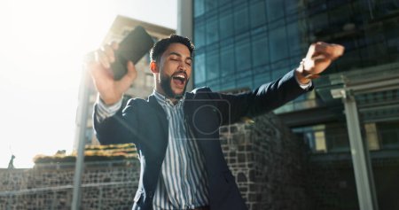 Photo for Phone, dance and success with a businessman in the city for increase, bonus or promotion celebration. Wow, mobile and a winner young employee cheering for goals, target or corporate achievement. - Royalty Free Image