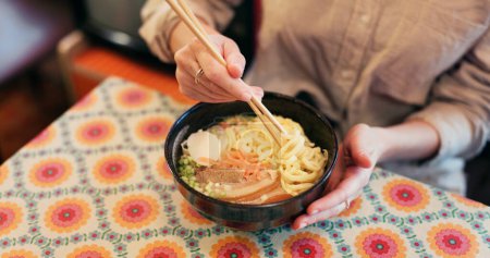 Photo for Ramen food, plate and table in restaurant with person, hands and ginger with closeup for Japanese cuisine. Niboshi bowl, chopsticks and pork for diet, nutrition and catering for wellness in Tokyo. - Royalty Free Image