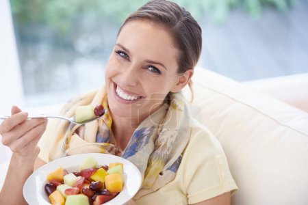 Photo for Food, happy woman in portrait and fruit in salad for diet, organic meal and relax on sofa with smile for weight loss. Vegan, gut health and wellness, healthy eating for nutrition with vitamins. - Royalty Free Image