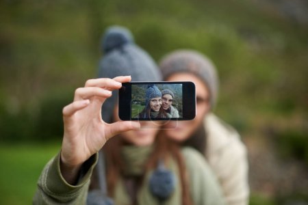 Photo for Couple, selfie and photo while hiking in nature, smartphone and capture moment in outdoors. People, happy and picture for memory and exploring wilderness, trekking and photograph for social media. - Royalty Free Image