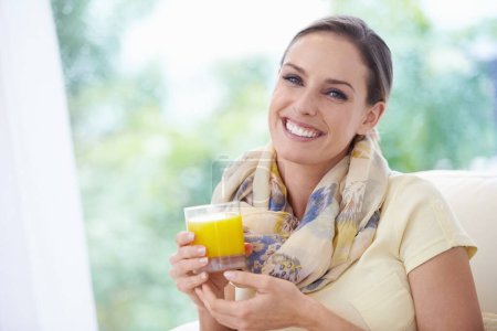 Téléchargez les photos : Portrait, sourire ou femme heureuse à la maison avec du jus d'orange pour la vitamine c dans le salon pour se détendre lors d'une pause. Appartement, bien-être ou femme buvant une boisson fraîche pour une alimentation saine ou une hydratation. - en image libre de droit