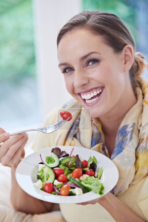 Téléchargez les photos : Femme, manger de la salade et des aliments sains pour l'alimentation, les légumes et le déjeuner avec bonheur dans le portrait. Nutrition, bien-être et repas végétalien pour perdre du poids avec sourire, désintoxication et collation pour le dîner à la maison. - en image libre de droit