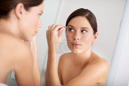 Foto de Belleza, reflejo de espejo y mujer con pinzas para el mantenimiento de cejas, depilación o tratamiento cosmético. Baño en casa, autocuidado matutino y aseo de personas con herramientas de desplumado facial. - Imagen libre de derechos