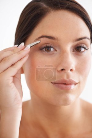 Photo for Plucking, eyebrow and portrait of woman with beauty, tweezers and self care in bathroom. Makeup, routine and girl with hair removal, tools and facial grooming or cleaning for skincare and cosmetics. - Royalty Free Image