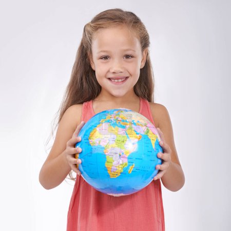 Photo for Child, portrait and globe in studio with world, planets and city for education, geography and happy. Student, girl kid and travel map with smile for earth day support or lesson on white background. - Royalty Free Image