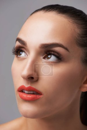 Photo for Face, beauty and woman is thinking with makeup, cosmetics and orange lipstick on grey background. Inspiration, insight and dream with model in studio, lashes and glamour with elegance and skin. - Royalty Free Image