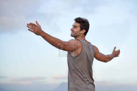 Photo for Sky, happy and excited with man, vacation and journey with wellness and freedom with adventure. Person, outdoor and guy with arms raised, peace and happiness with holiday and adventure with smile. - Royalty Free Image