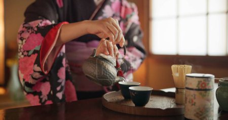 Téléchargez les photos : Japonais, mains et matcha pour la cérémonie du thé dans la salle Chashitsu avec robe kimono et coutume traditionnelle. Personnage, temae et tenue vintage pour la culture, la mode et l'honneur avec vaisselle antique. - en image libre de droit