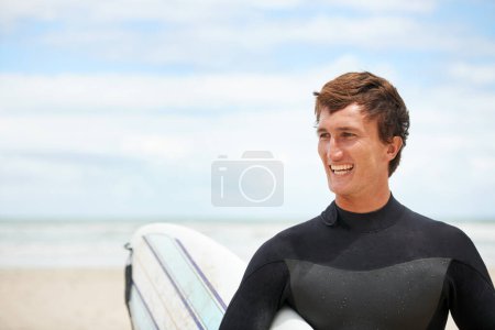 Photo for Surfing, happy and man with surfboard on beach for water sports training, freedom and fitness outdoors. Nature, smile and person with mockup space for adventure on holiday, vacation and hobby by sea. - Royalty Free Image