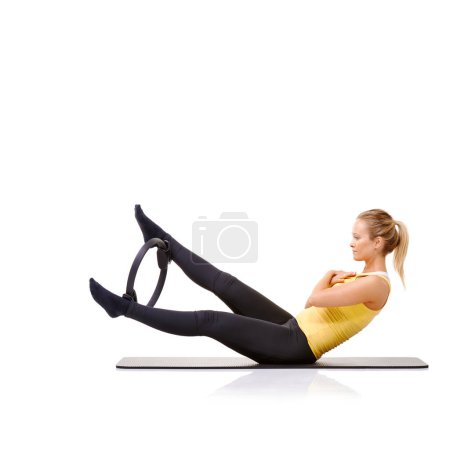 Photo for Woman, pilates ring and legs for balance exercise for resistance training, strong core or studio white background. Female person, equipment for thigh muscle wellbeing or abs workout, health or mockup. - Royalty Free Image