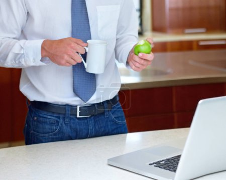 Photo for Laptop, apple and hands of business man in home for morning routine, remote work and healthy breakfast. Wellness, worker and person with fruit on computer for website, research and internet in house. - Royalty Free Image