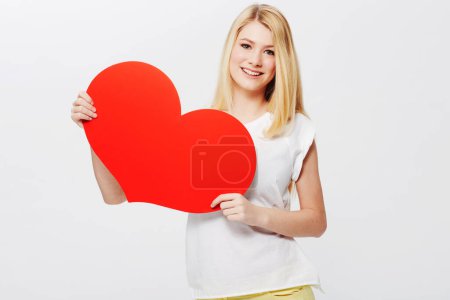 Photo for Woman, portrait and heart or poster mockup as love message, announcement or bulletin. Female person, model and face or white background in studio as valentines gesture or billboard, placard or banner. - Royalty Free Image
